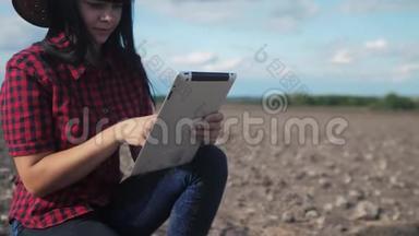 智慧生态是一种收获农业的耕作理念。 女农民用数字平板电脑研究地球上的泥土